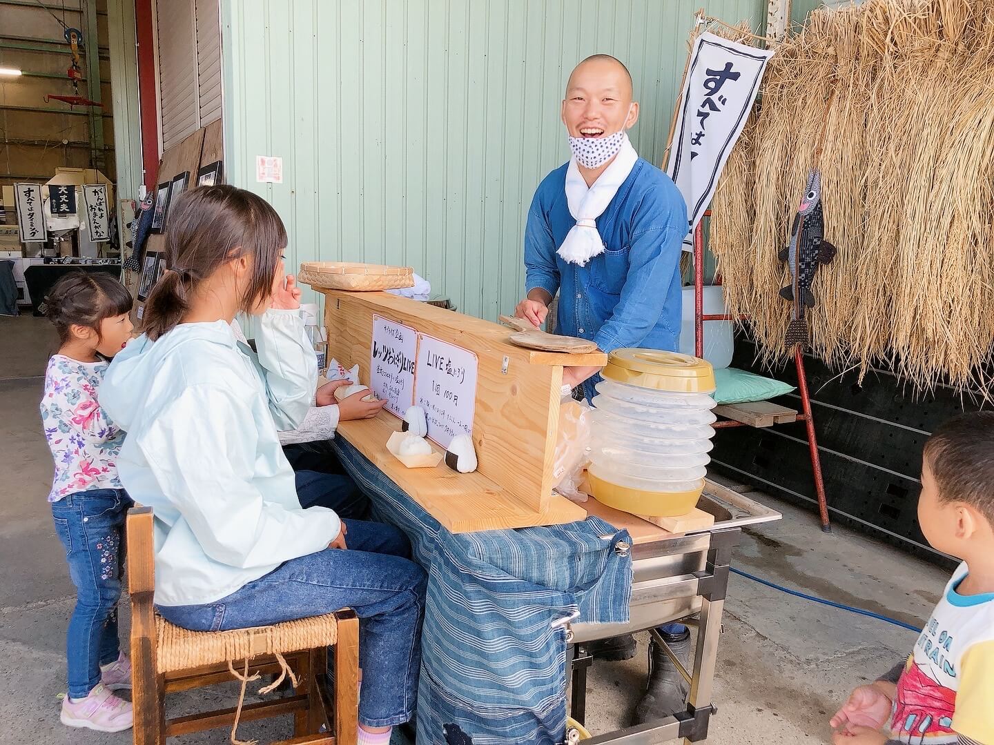 カウンター席でおにぎりを食べる子供たちと、青松さんの笑顔